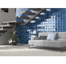 Wohnzimmer mit blauen Wandfliesen, Treppe und Sofa