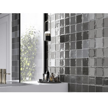 Badezimmer mit grauen Wandfliesen und Waschtisch