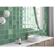 Badezimmer mit grünen Fliesen, Waschbecken und Spiegel