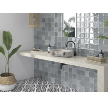 Badezimmer mit Waschbecken aus Stein, grauen Fliesen und gemusterten Bodenfliesen für ein helles und organisiertes Ambiente.