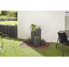 Gartenszene mit Pflanzsteinen in verschiedenen Größen und Bepflanzung auf Rasenfläche