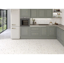 Küchenszene mit grauen Schränken, weissem Kühlschrank und Bodenfliesen im Terrazzo-Stil