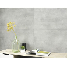 Wandgestaltung mit grauen Fliesen im Betonlook als Hintergrund für Dekoration auf einem Sideboard