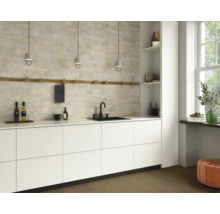 Moderne Küche mit weißen Schränken, Steinwand und schwarzen Armaturen