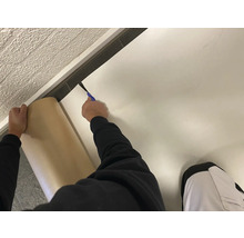 Verlegen von Bodenbelag mit einem Cuttermesser