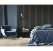 Schlafzimmer mit Bett, Sessel, Stehlampe, Nachttisch und Wandpaneelen