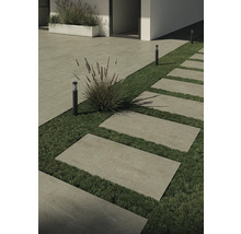 Außenaufnahme mit Steinplatten als Gehweg und Rasenflächen, kombiniert mit Bepflanzung und Außenleuchten.