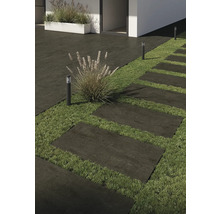 Außenaufnahme mit Terrassenplatten, Rasen und Außenleuchten.