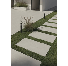 Außenbereich mit rechteckigen Terrassenplatten auf Grasfläche und dezenten Außenleuchten