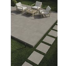 Terrasse mit Outdoor-Sitzgruppe und quadratischen Steinplatten auf Rasen