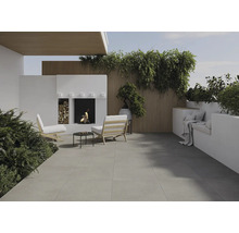 Terrasse mit Steinboden, Sitzgelegenheiten, Kamin und Pflanzen für eine gemütliche Atmosphäre im Freien