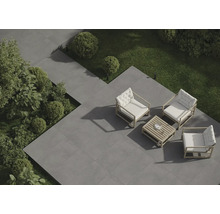 Terrasse mit grauen Fliesen, Gartenmöbeln und Grünpflanzen von oben