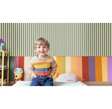 Helles Kinderzimmer mit gestreifter Tapete und lächelndem Kind