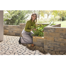 Frau arbeitet im Garten mit Pflanzsteinen und Bodenplatten