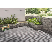 Terrasse mit Pflanzkästen aus Mauersteinen und Holzspielzeug