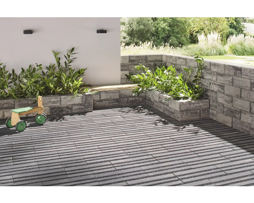 Terrasse mit Pflanzkästen aus Mauersteinen und Holzspielzeug