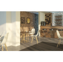 Innenraum eines Cafés mit Tischen, Stühlen und Barhockern vor einer Ziegelwand