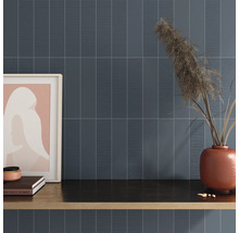 Wandgestaltung mit länglichen Fliesen und dekorativen Elementen auf einer Ablagefläche