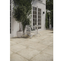 Außenbereich mit Terrassenplatten, Rattansessel und Dekoration