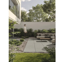 Terrasse mit Gartenmöbeln, Steinplatten und Bepflanzung vor einem modernen Haus