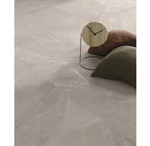 Fliesenboden mit Marmoroptik, Kissen und dekorativer Uhr.