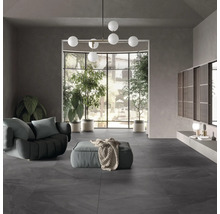 Wohnzimmer mit grauen Bodenfliesen, Sofa und Zimmerpflanzen.