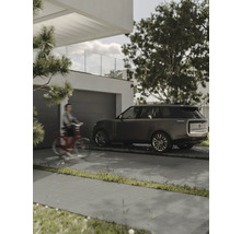 Modernes Wohnhaus mit Garage, PKW und Person auf Fahrrad