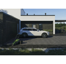 Modernes Wohnhaus mit Garage, Rasenmäher und PKW auf gepflasterter Auffahrt