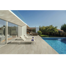 Terrasse mit Fliesen, Pool und Liegestühlen vor modernem Haus