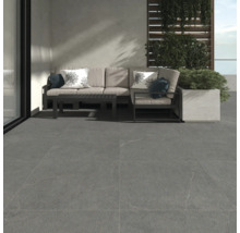 Terrasse mit grauen Bodenfliesen, Sofa, Couchtisch und Pflanzenkasten