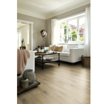 Wohnzimmer mit heller Holzbodenoptik, weißem Sofa und industriellem Couchtisch