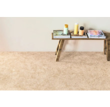 Innenaufnahme eines hellen Wohnraums mit Teppich und einem rustikalen Holztisch mit Dekoration