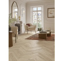 Heller Wohnraum mit Fischgrätparkett, Sesseln und Kamin