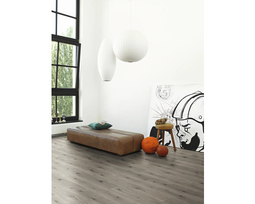 Heller Raum mit grauer Laminatboden, brauner Sitzbank, Kunstwerk und großen Fenstern für eine freundliche Atmosphäre