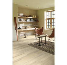 Heller Raum mit Holzfußboden, Regalen, Dekoration und zwei Ledersesseln