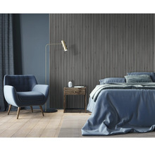Schlafzimmer mit Bett, Sessel, Stehlampe, Nachttisch und Wandpaneelen
