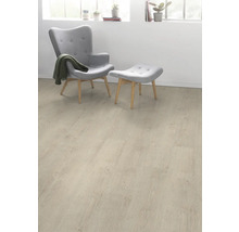 Heller Laminatboden in einem Wohnraum mit Sessel und Fußhocker.