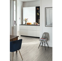 Heller Raum mit Küchenzeile, Stühlen und hellem Holzboden.