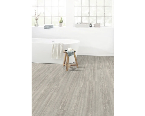 Helles Badezimmer mit freistehender Badewanne, Holzhocker und Boden in Holzoptik.