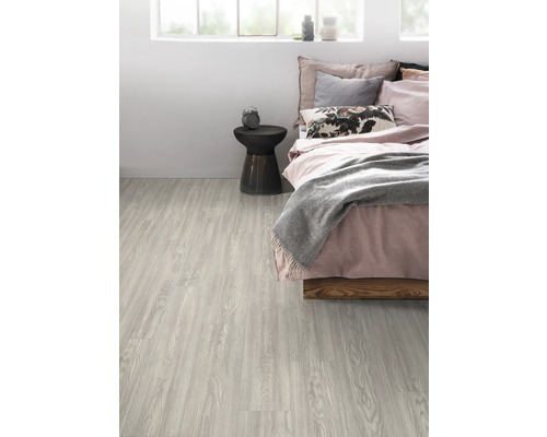Heller Laminatboden in einem Schlafzimmer mit Bett und Beistelltisch.