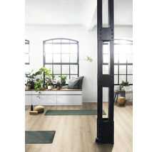 Heller Raum mit Laminatboden, Fensterfront, Sitzbank mit Pflanzen und Yoga-Matten.