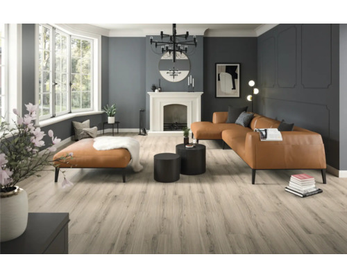 Heller Wohnraum mit Sofa, Ottomane, Couchtischen, Kamin und Holzboden