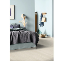 Helles Schlafzimmer mit Bett, Textilien, Wandhaken und Dekoration