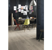 Esstisch mit Stühlen und hellem Holzboden vor einer dunklen Wand mit Bildern