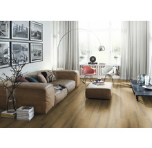 Wohnzimmer mit Sofa, Sessel, Stehlampe und Holzfußboden