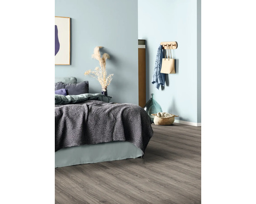 Schlafzimmer mit Bett, Dekoartikeln, Garderobe und Holzfußboden