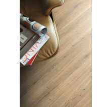 Nahaufnahme von Laminatboden mit Holzoptik neben einem Sessel