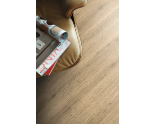 Nahaufnahme von Laminatboden mit Holzoptik neben einem Sessel