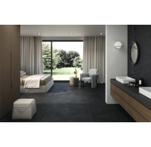 Helles Schlafzimmer mit Badezimmer und dunklem Steinboden