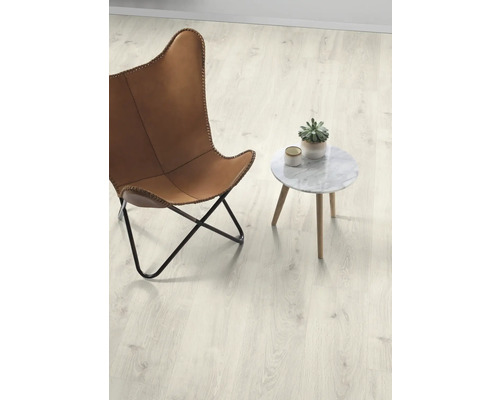 Heller Laminatboden mit Sessel und Tisch im Raum.